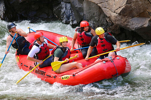 Happy clients rafting through rapids